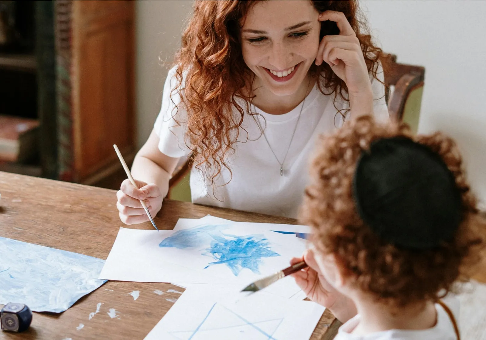 A parent and young child painting together at a table